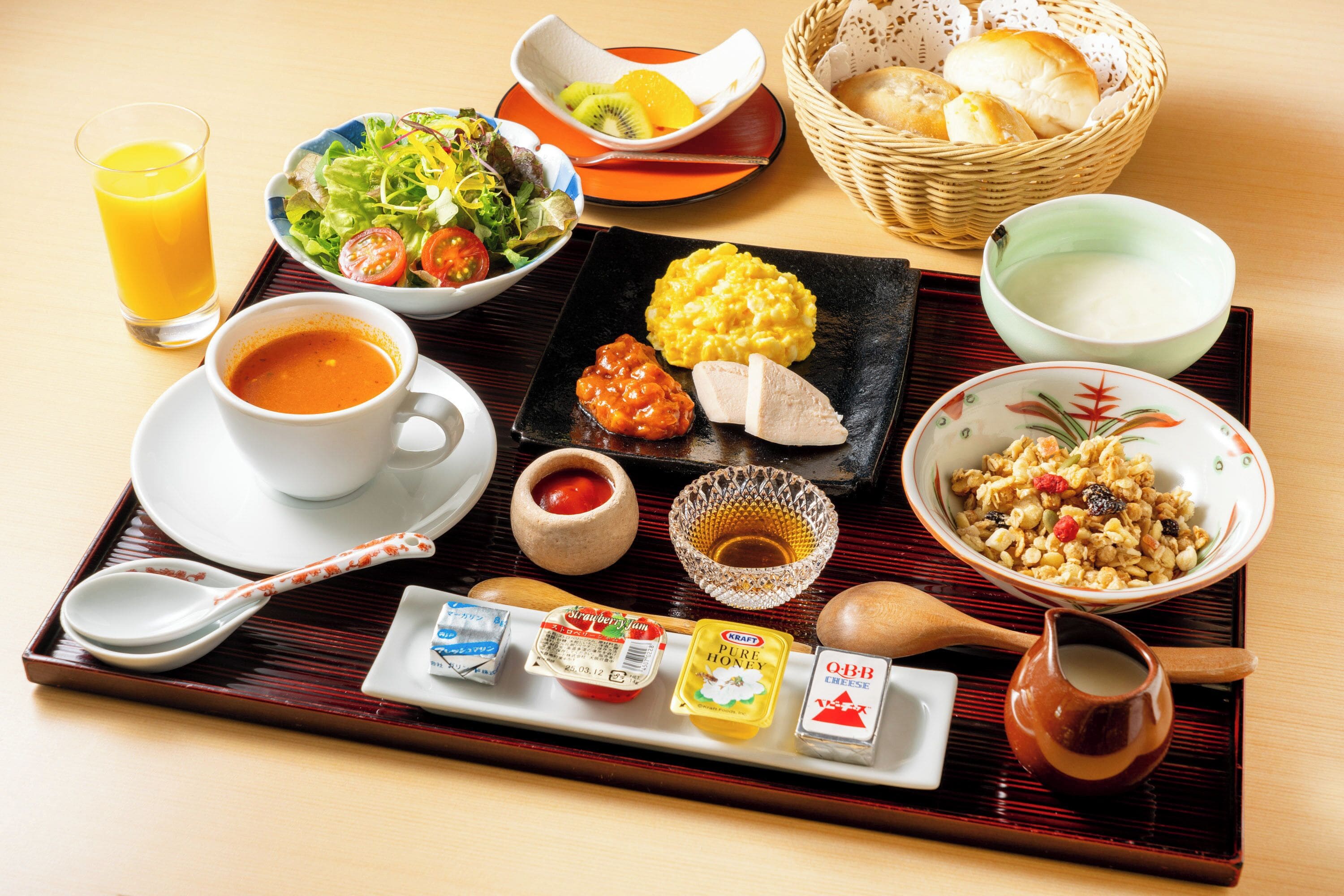 A tray with various breakfast items including eggs, bread, and a bowl of cereal.