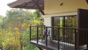 A balcony with a wooden railing, a table, and two chairs. - Lima Bella Resort (Rayong)