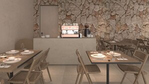 A modern dining area with a stone wall backdrop, a coffee machine, and neatly set tables. - Jerusalem Metropole Hotel (Jerusalem)