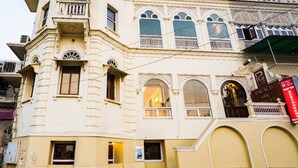 Een historisch pand met weelderige architectonische versieringen, waaronder gebogen ramen en decoratieve balkons.