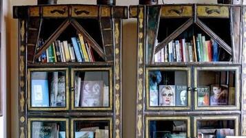 A room with a bookshelf containing books and decorative items.