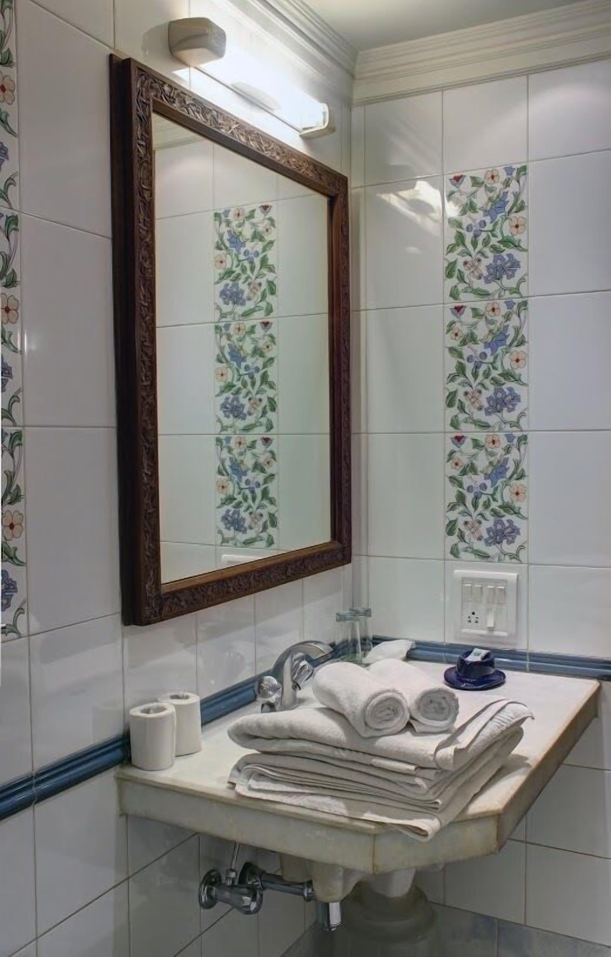 Une salle de bain avec un lavabo, un miroir et des serviettes.