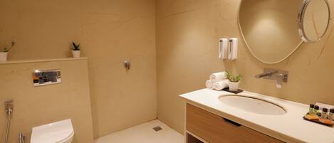 Une salle de bain moderne équipée de toilettes, d’un lavabo et d’une douche.