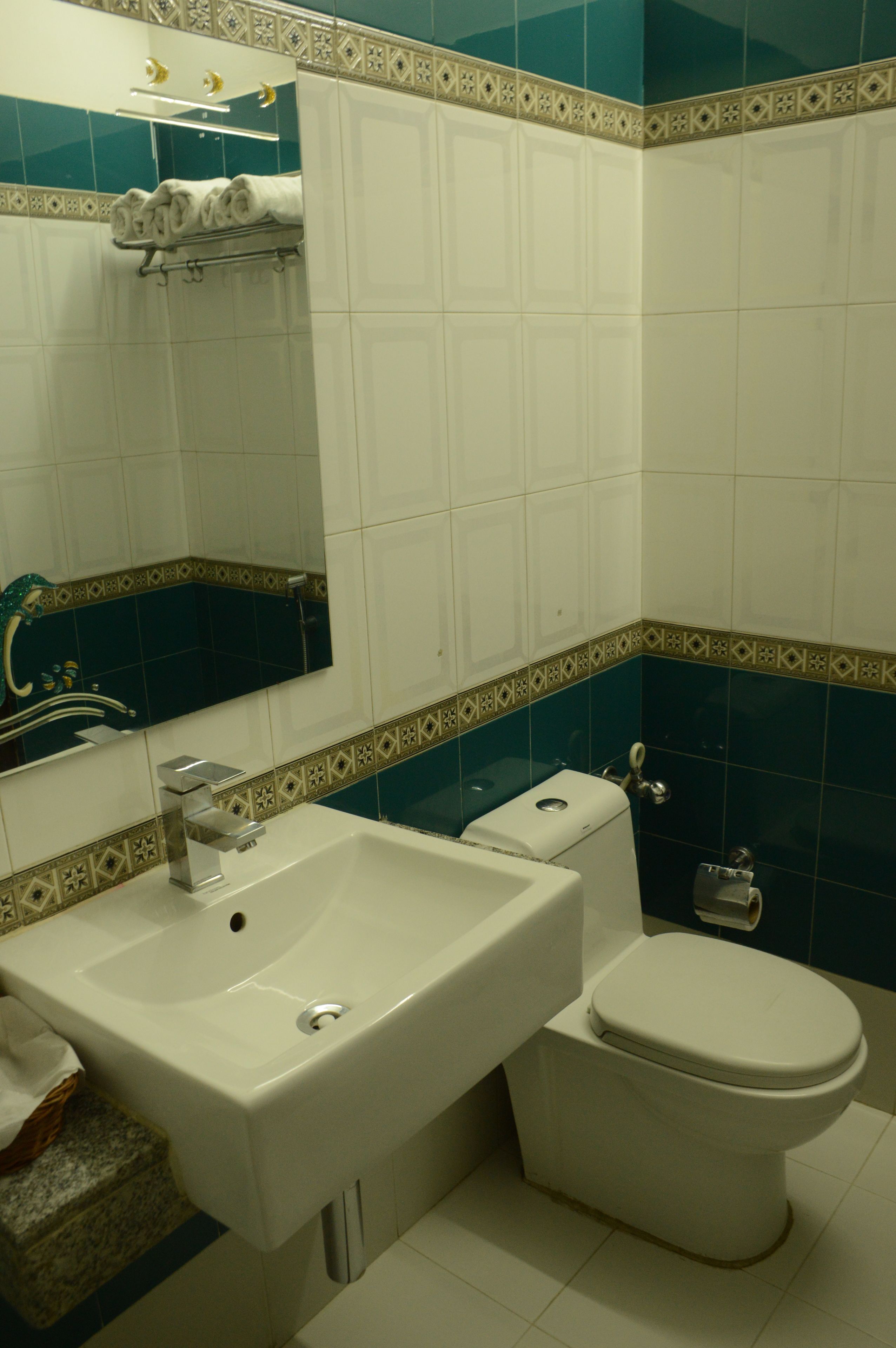 A bathroom with a white sink, a toilet, and a mirror.