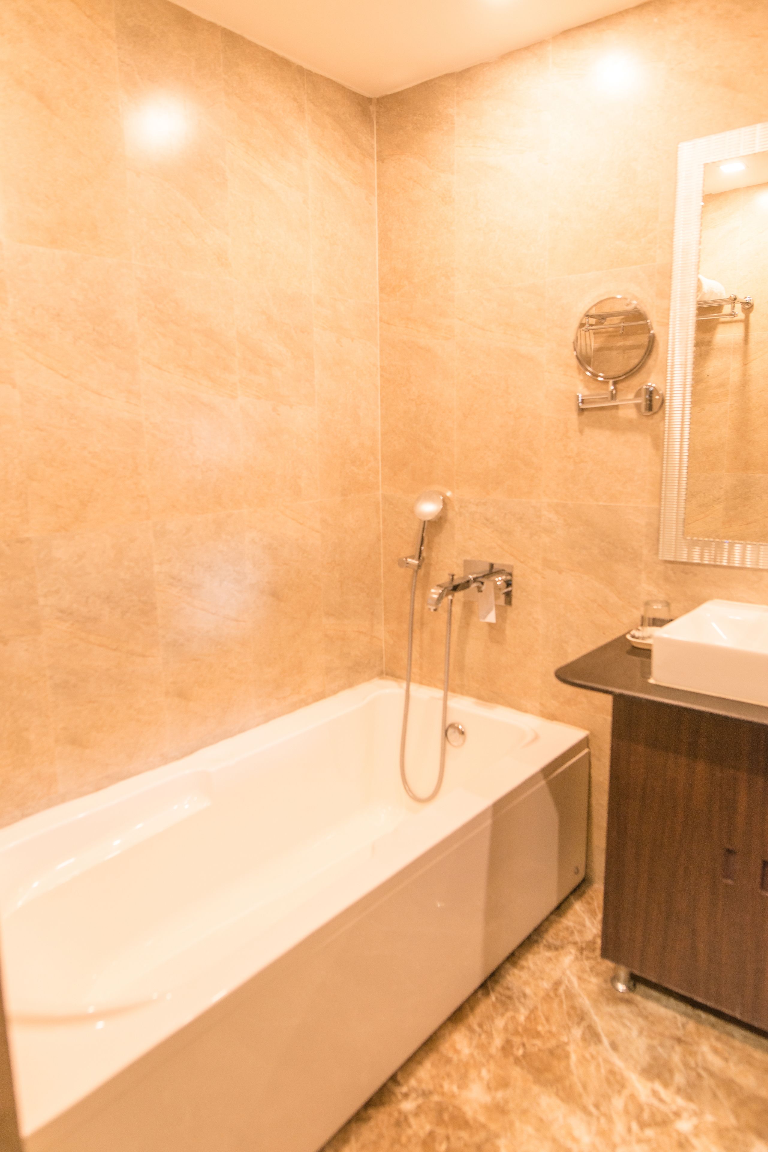 A modern bathroom with a bathtub, a sink, and a mirror.