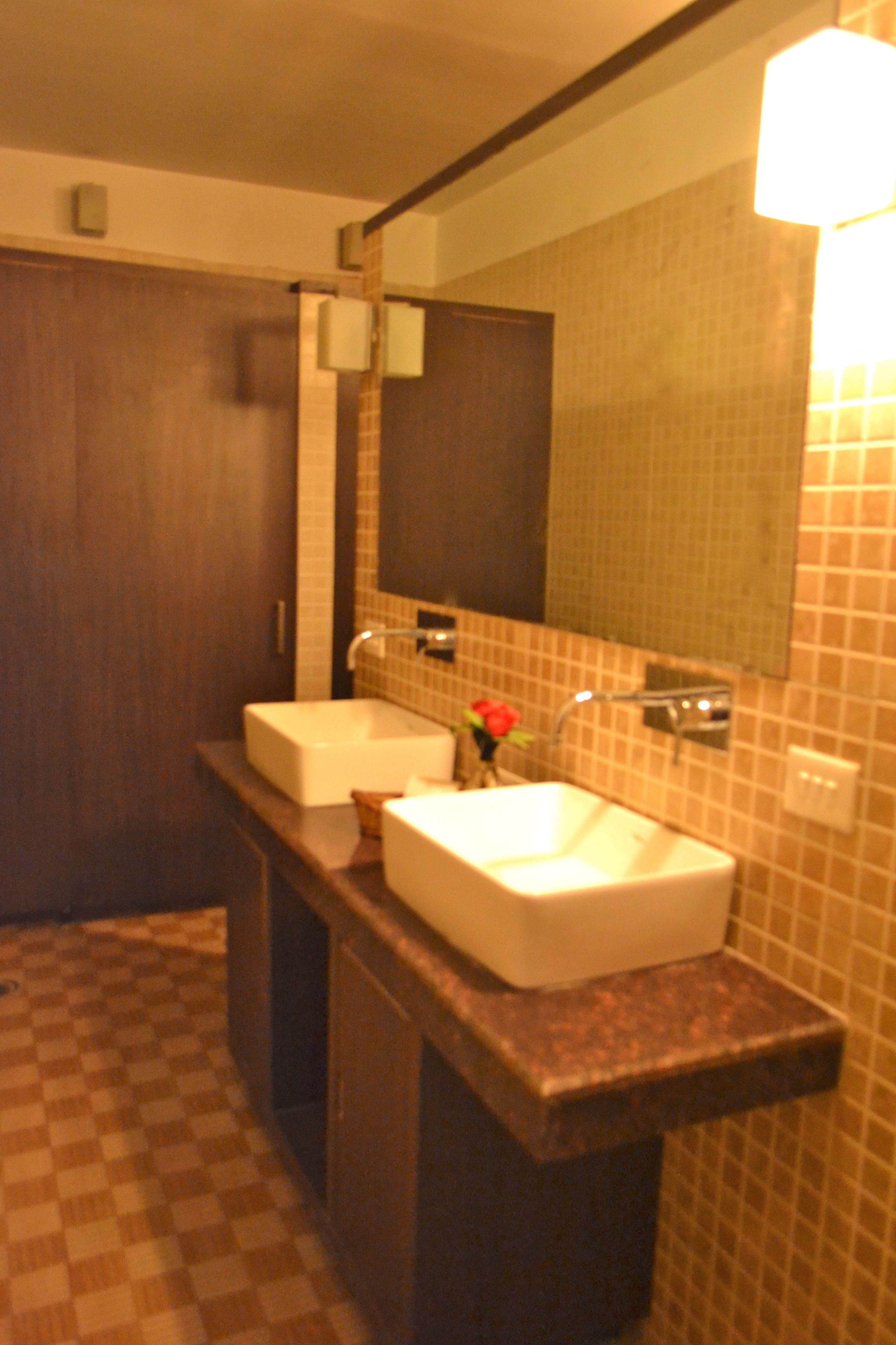 A bathroom with a checkered floor, a double sink, and a mirror.