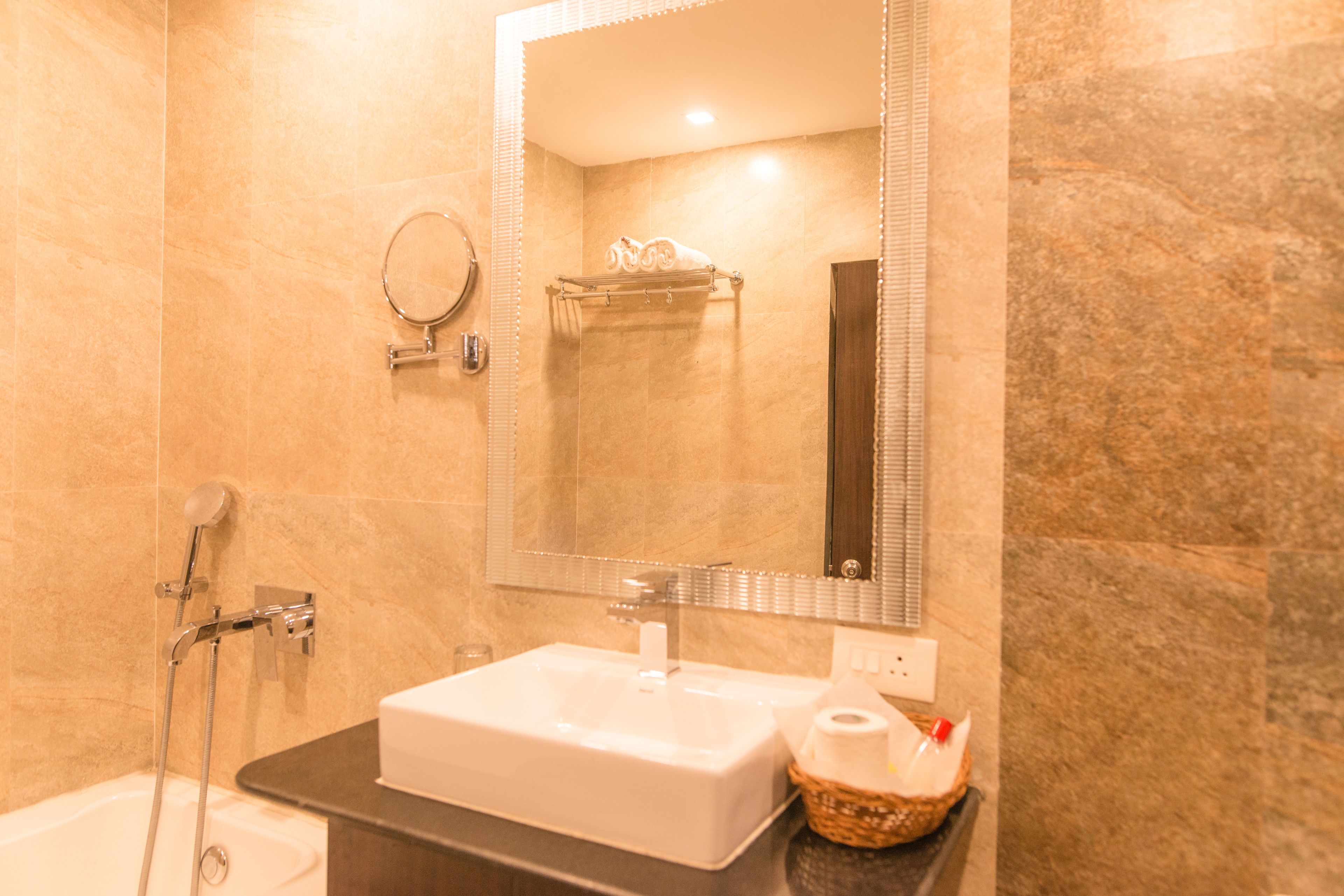 A bathroom with a white sink, a mirror, a towel rack, and a shower.