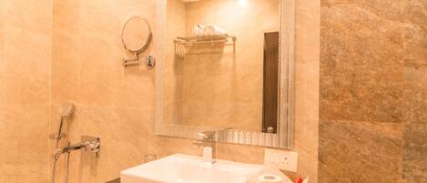 A bathroom with a white sink, a mirror, a towel rack, and a shower.
