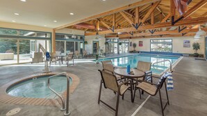 A pool area with a hot tub, lounge chairs, and a table with umbrellas. - WorldMark McCall (McCall)