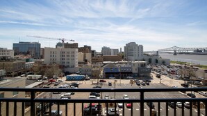 A cityscape with a bridge in the background, a parking lot, and various buildings.