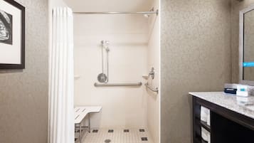A bathroom with a shower, a sink, and a mirror.