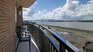 Un balcon avec vue sur une rivière et un pont.