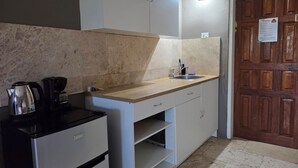 A compact kitchen with a countertop, sink, and a coffee maker. - The Lodge Bonaire (Kralendijk)