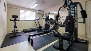 A gym with exercise equipment, a treadmill, and a mirror.