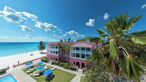 A pink building with balconies overlooking a beach. - Southern Palms Beach Club (St. Lawrence Gap)