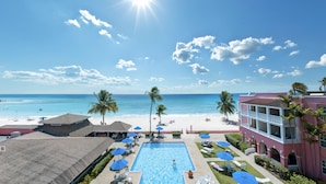 Een resort met een zwembad, strand en uitzicht op de oceaan.
