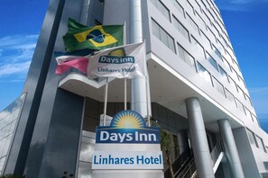 A Days Inn Linhares Hotel sign with a Brazilian flag and a Sun Inn logo.