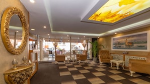 A lobby with a checkered floor, a large mirror, and a painting of a boat on the wall. - Regno Hotel (Istanbul)