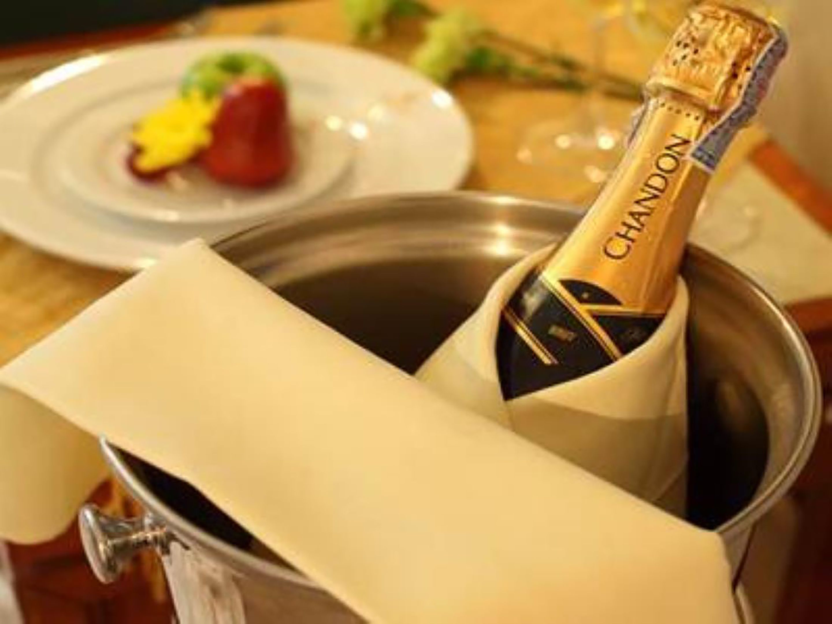 Een champagnefles in een metalen emmer met een witte servet.