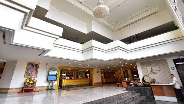 A hotel lobby with a reception desk, a chandelier, and a large painting on the wall. - Hansa JB Hotel (Hat Yai)