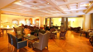 A spacious lobby with a high ceiling, multiple seating areas, and a central bar. - Hansa JB Hotel (Hat Yai)