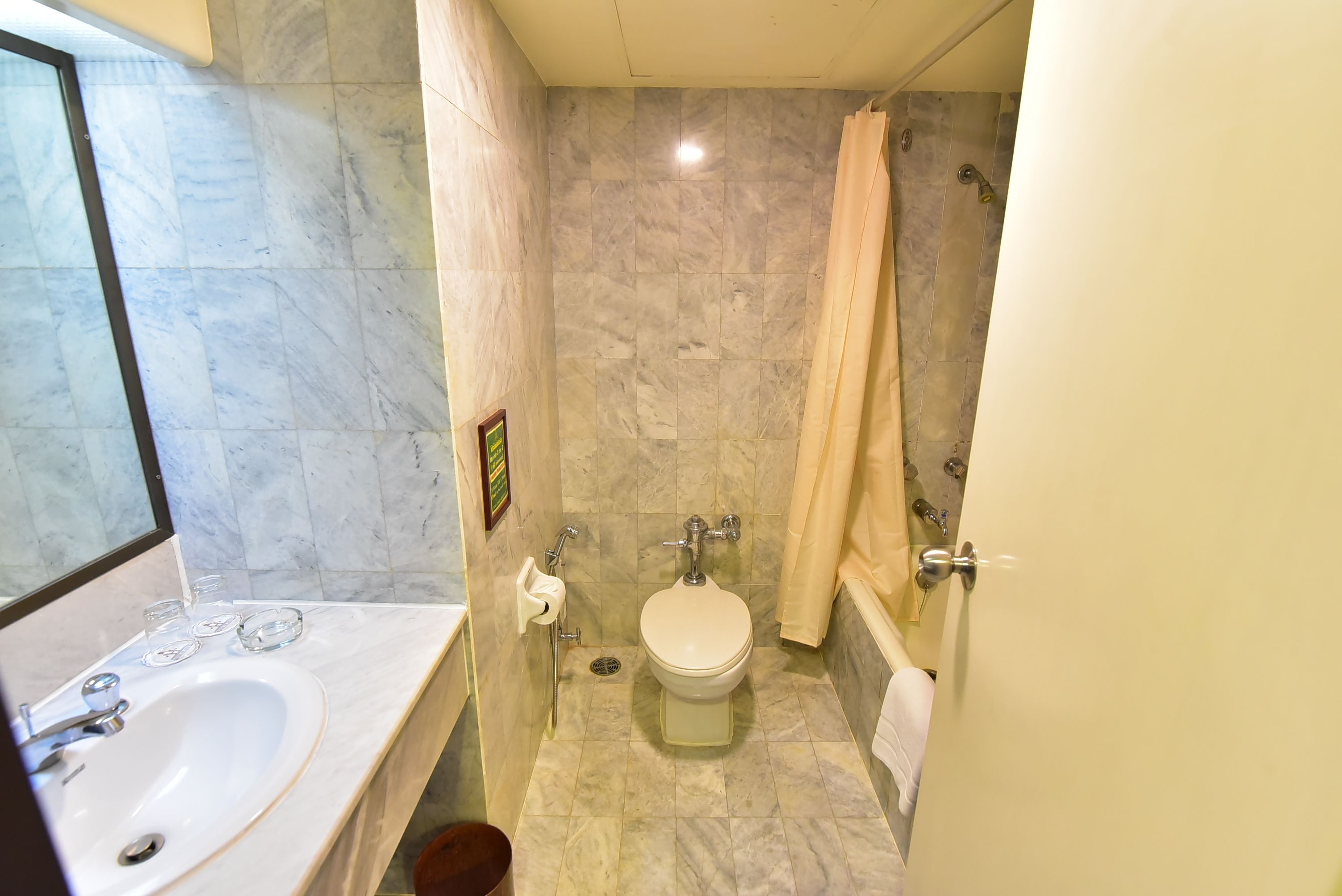 Een badkamer met wastafel, toilet en douche.