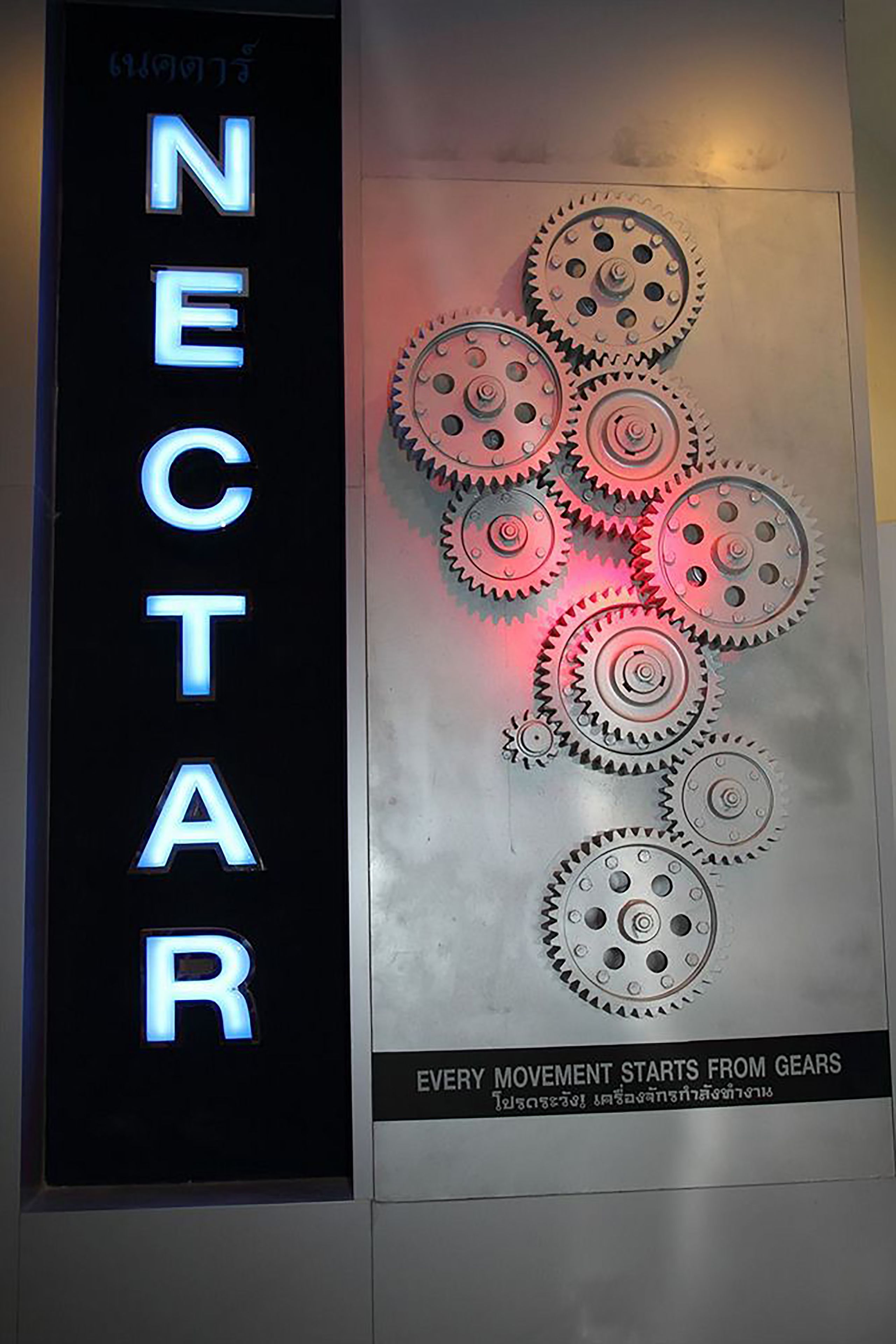 Un letrero con la palabra 'NECTAR' y un diseño de engranaje.
