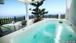 A rooftop pool with a clear view of the ocean, surrounded by blue fencing and outdoor furniture. - Villa Happening (Santorini)
