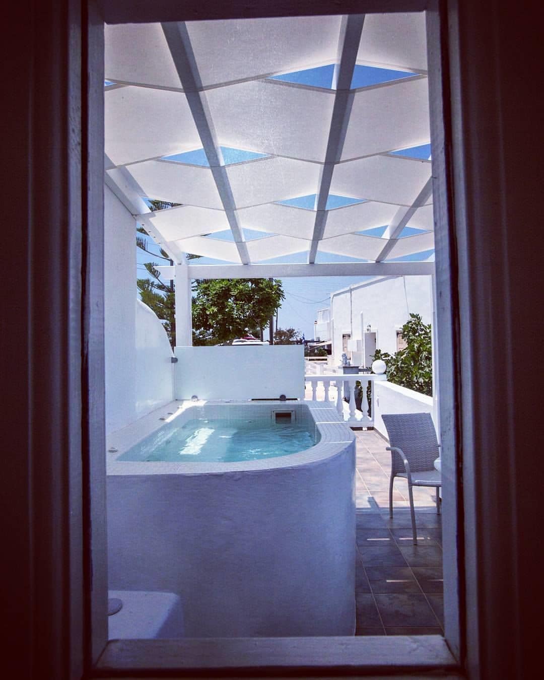 A spa area with a hot tub and a covered patio.