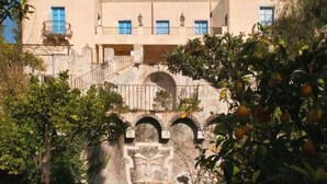 Un edificio con varios balcones, una escalera y un arco de piedra.
