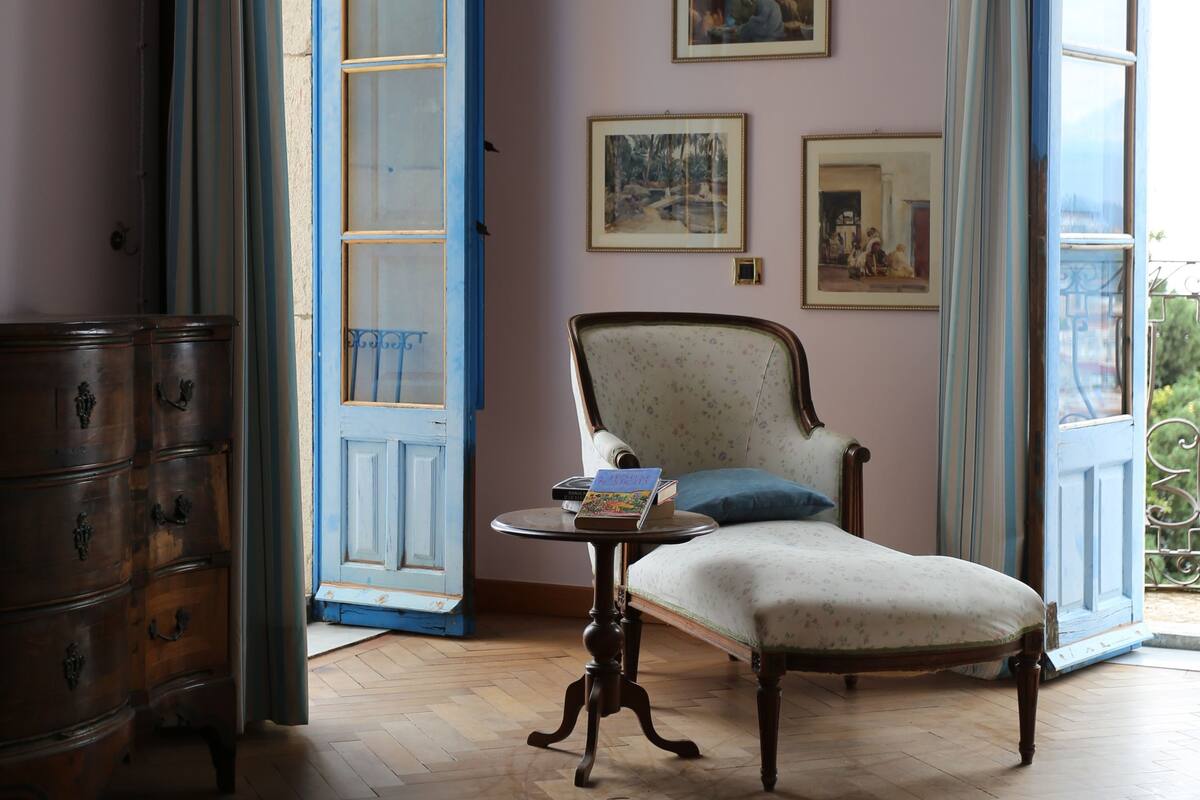 A room with a wooden floor, a chair, a dresser, and a table with a book.
