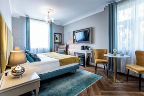 A hotel room with a bed, desk, TV, chairs, and a coffee machine. - Villa Antonina (Sopot)