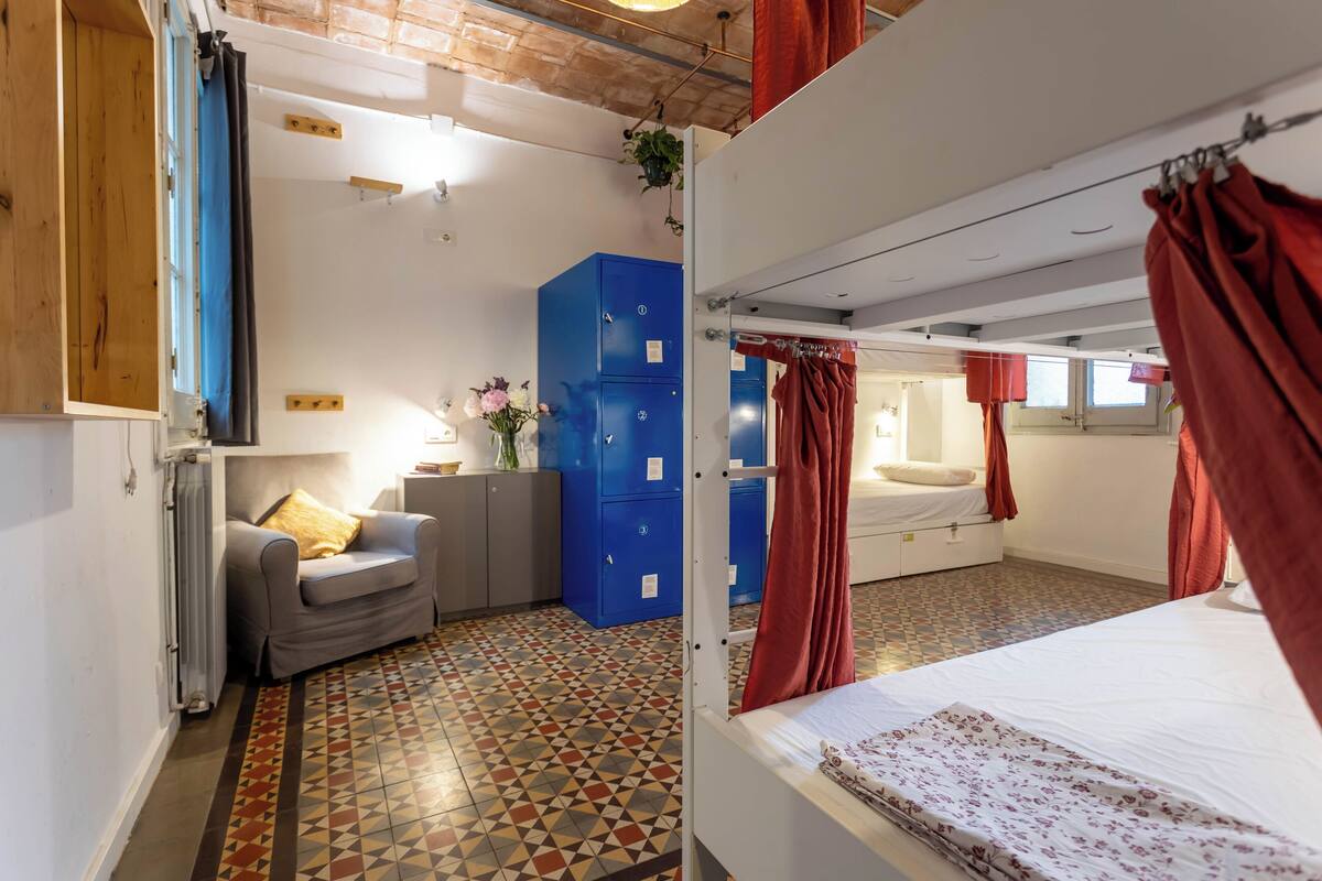 Ein Zimmer mit einem Bett, einer Schlafcouch, einem blauen Schrank und einem Heizkörper.