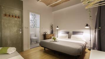 Une chambre à coucher avec un lit, une table de chevet, une lampe et une vue sur la salle de bain.