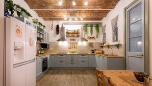 Una cocina moderna con armarios azul claro, encimera de madera y techo de ladrillo.