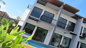 A modern multi-story building with balconies, large windows, and a swimming pool. - Alphabeto Resort (Rawai)