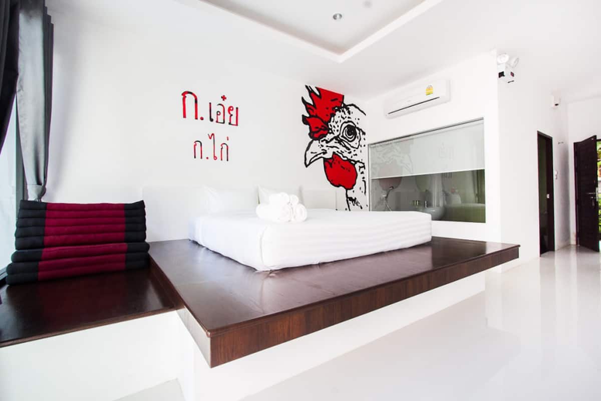 Una habitación de hotel moderna con una cama grande, un aire acondicionado de pared y un ventanal amplio.