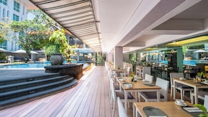 A poolside area with outdoor seating and a bar. - Bintang Kuta Hotel (Kuta)