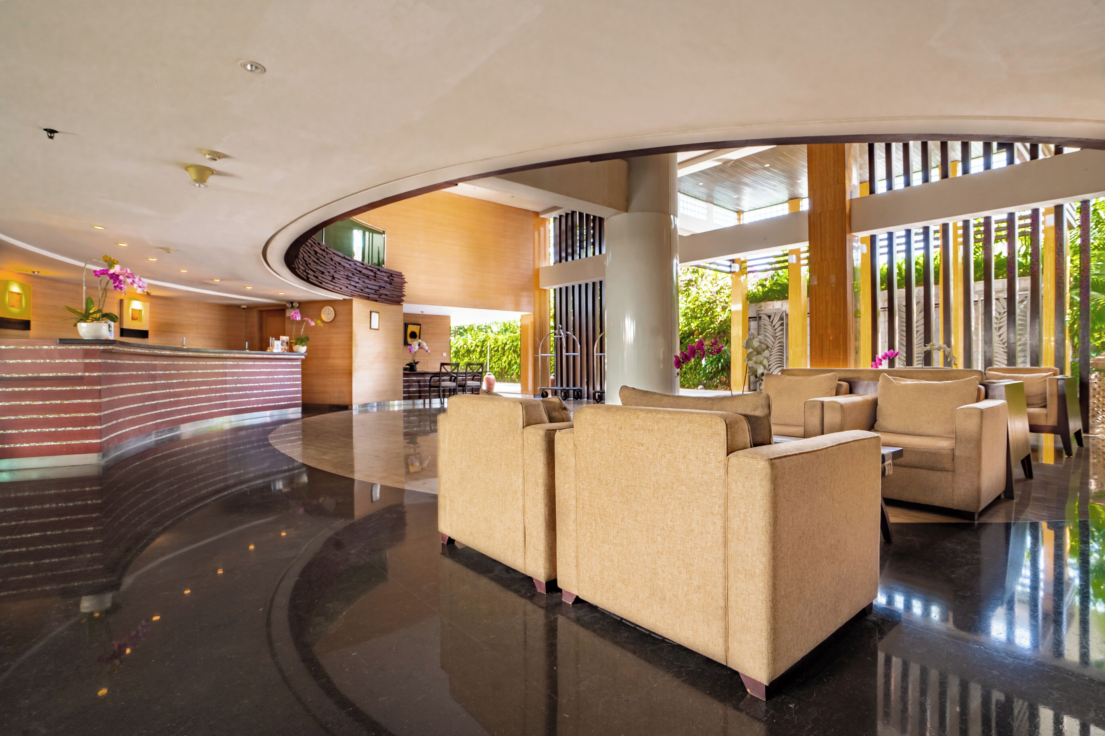En rummelig lobby med en buet receptionsdisk, komfortable siddeområder og et moderne design.