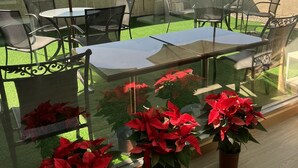 An outdoor seating area with tables and chairs, green umbrellas, and potted plants. - LinkWorld Hotel Taipei (Taipei)