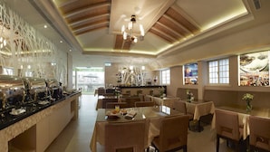 A hotel dining area with a buffet, tables, chairs, and a view of the cityscape through large windows. - LinkWorld Hotel Taipei (Taipei)