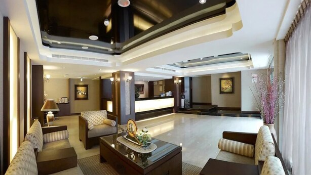 A spacious hotel lobby with a reception desk, seating areas, and a modern ceiling design. - LinkWorld Hotel Taipei (Taipei)