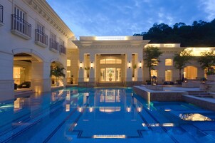 Una piscina techada, una piscina al aire libre, sombrillas