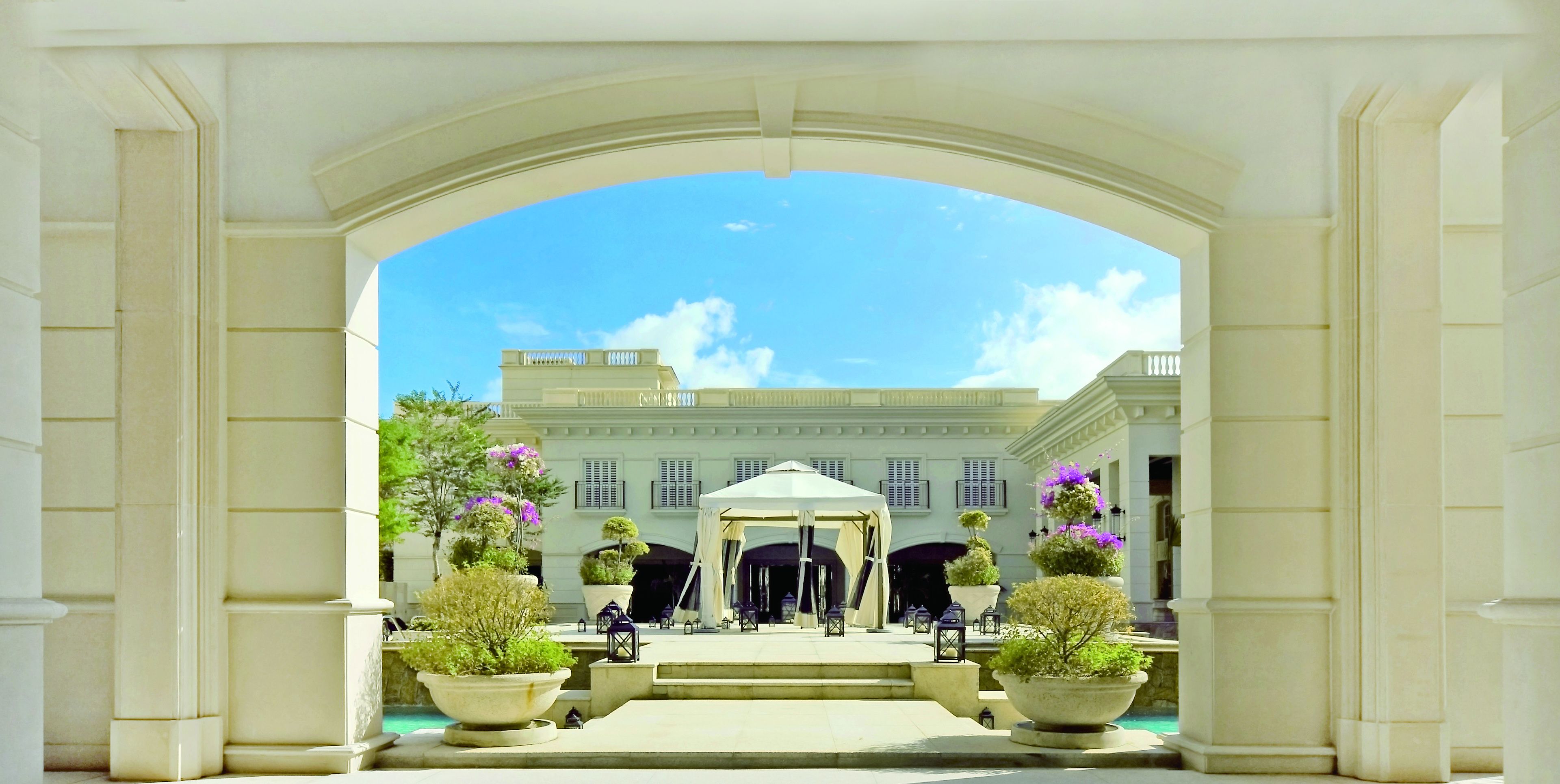 An arched entrance to a building with a clear sky above.