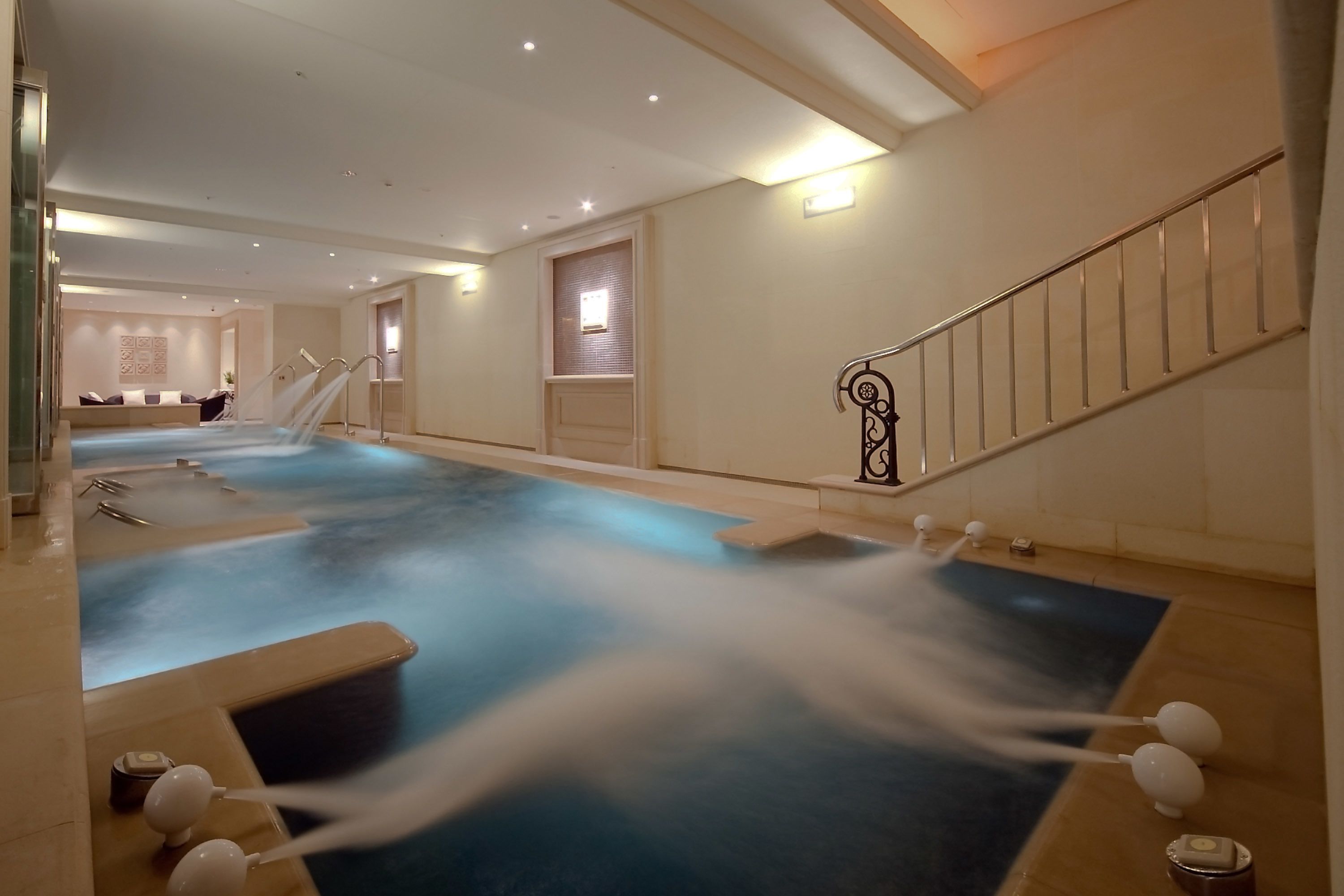 A spa area with a large hot tub, a staircase, and a reception desk.