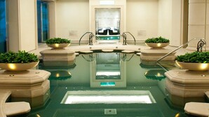 A large indoor swimming pool with a central diving platform, surrounded by lounge chairs and potted plants. - RSL Cold & Hot Springs Resort Suao (Suao)