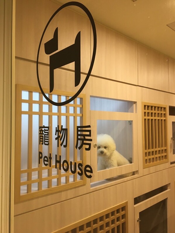 A pet house with a dog inside, wooden panels, and a sign with Japanese characters. - RSL Cold & Hot Springs Resort Suao (Suao)