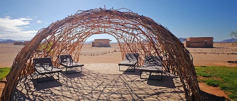 Een buitenzwembad, ligstoelen bij het zwembad