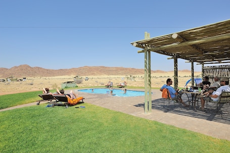 Alberca al aire libre y camastros