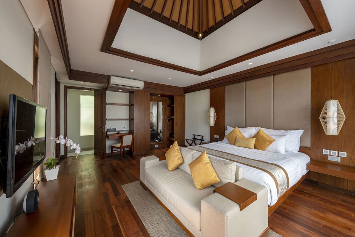Een moderne hotelkamer met een groot bed, een slaapbank, een bureau en een televisie.